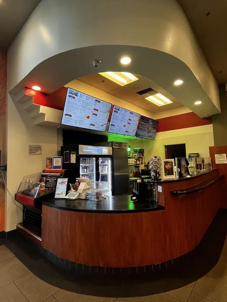The MexiBites counter inside City Sports Club, with the menu screens and the juice cooler